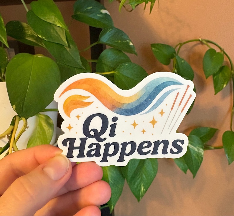 May include: A sticker with the text "Qi Happens" in a navy blue font. The sticker features a colourful design with orange, yellow, and blue waves, along with several gold stars and acupuncture needles.