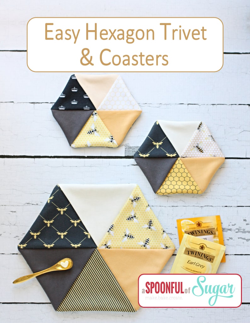 May include: Hexagon trivets and coasters with a bee theme. The trivets are made of fabric in various patterns, including bees, honeycomb, and stripes. The color palette includes black, gray, yellow, and cream. The image also includes a gold spoon and tea bags.