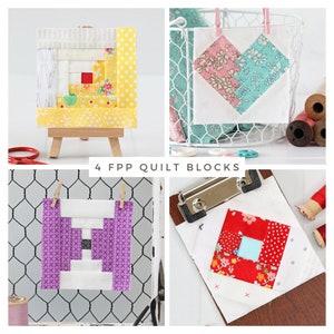May include: Four fabric patchwork quilt blocks in various colors and patterns. The blocks are displayed on a white wire mesh background, a wooden easel, and a clipboard. The blocks feature a heart, a log cabin, and two different squares.