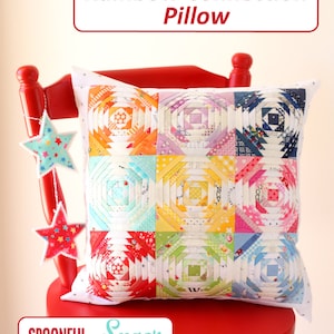 May include: A colourful rainbow connection pillow with a white background and a pineapple pattern. The pillow is sitting on a red chair. The text "a SPOONFUL of Sugar" is visible in the bottom left corner of the image.