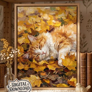 Puede incluir: Una pintura al óleo en un marco de madera clara que representa a un gato atigrado y blanco durmiendo plácidamente entre un montón de hojas de otoño amarillas y naranjas. La obra presenta pinceladas gruesas y texturizadas e incluye una etiqueta de descarga digital.