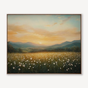 May include: A framed landscape painting depicts a field of white flowers bathed in golden sunlight. Mountains are visible in the distance under a sky of orange and blue hues. The artwork is encased in a brown frame.