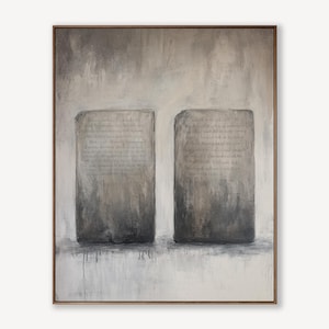 May include: Abstract painting featuring two rectangular, stone-like forms with text, set against a muted gray and white background. The artwork is framed in a thin, brown wooden frame, creating a minimalist aesthetic.