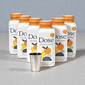 May include: Six white bottles with orange caps and the text "Dose for your liver" are arranged around a small silver cup. Each bottle features an orange and leaf design. The bottles contain a dietary supplement, net 16 fl oz (472 ml).