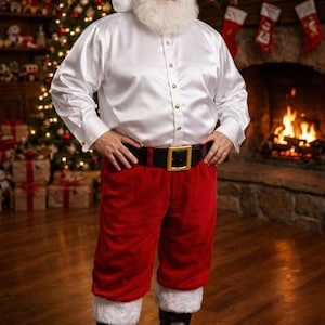 May include: A Santa Claus costume featuring a long-sleeved white satin button-down shirt with gold buttons, red velvet trousers with white faux fur trim at the cuffs, a black belt with a gold buckle, and a red velvet hat with white faux fur trim.