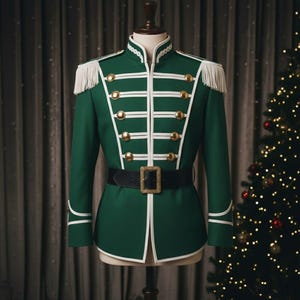 May include: A green military-style jacket with white trim, gold buttons, and a black belt with a gold buckle. The jacket has white fringe epaulets and is displayed on a mannequin. A Christmas tree is in the background.