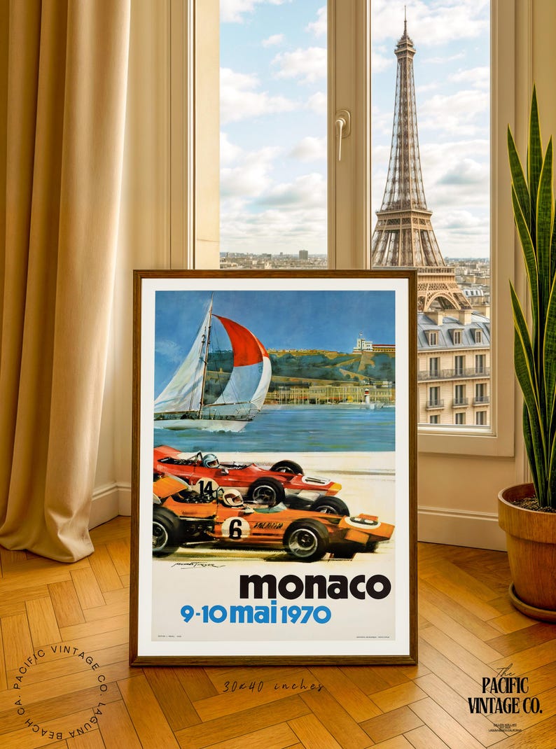 May include: Framed vintage poster for the Monaco Grand Prix, featuring race cars, a sailboat, and the text "monaco 9-10 mai 1970". The poster is 30x40 inches and is displayed in a room with a view of the Eiffel Tower.