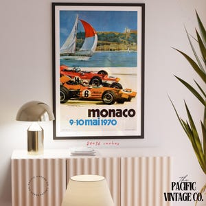 May include: Framed vintage Monaco Grand Prix poster. The poster features two race cars in orange and red, a sailboat, and the text "Monaco 9-10 mai 1970". The poster measures 24x36 inches.