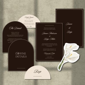 Puede incluir: Un conjunto de papelería de boda con tarjetas rectangulares y arqueadas de color marrón oscuro con tipografía blanca con serifa. El set incluye una invitación, tarjetas de detalles y tarjetas RSVP, junto a una ilustración de dos calas blancas.