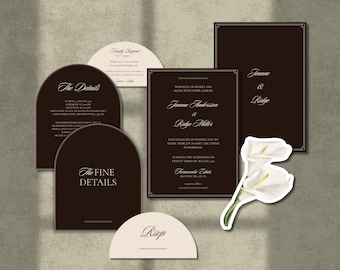 Op de afbeelding: Een trouwkaarten set bestaande uit donkerbruine rechthoekige en boogvormige kaarten met witte schreefletters. De set bevat een uitnodiging, detailkaarten en RSVP-kaarten, vergezeld van een gestanste illustratie van twee witte calla lelies.