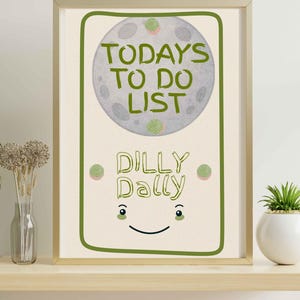 May include: A framed print with a light beige background features a green-outlined rectangle with a smiling face. The text "TODAYS TO DO LIST" is above "DILLY DALLY" in green. A gray circle with green spots is above the text.