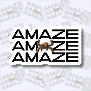 May include: A white sticker with the word "AMAZE" stacked three times in black, with a brown creature graphic in the center. The sticker has a white border and is on a white background with the word "AMAZE" repeated.