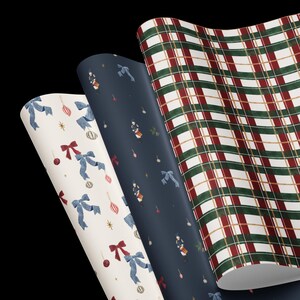 May include: Three rolls of wrapping paper featuring distinct holiday patterns. One roll has a white background with blue bows and red ornaments. The second roll is dark blue with small nutcracker figures. The third roll has a red, green, and white plaid.
