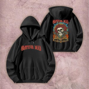 May include: Black hoodie with the text "Grateful Dead" in red across the chest. The back of the hoodie features a colorful graphic of a skull surrounded by roses and other floral elements, with the words "Grateful Dead" above.
