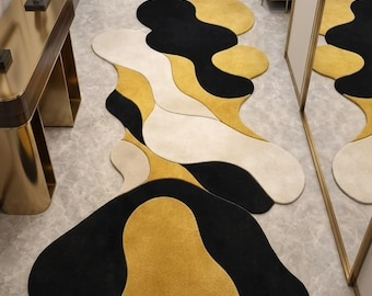 Alfombra de pasillo con diseño abstracto de ondas irregulares, alfombra moderna en negro, dorado y crema.