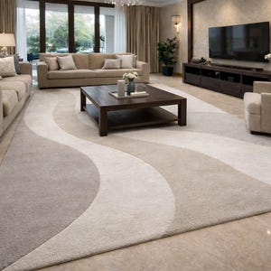 Op de afbeelding: Een moderne woonkamer met een groot vloerkleed met een golvend ontwerp in grijstinten en beige. De kamer omvat twee beige banken, een salontafel van donker hout en een grote flatscreen-tv, waardoor een comfortabele en stijlvolle ruimte ontstaat.