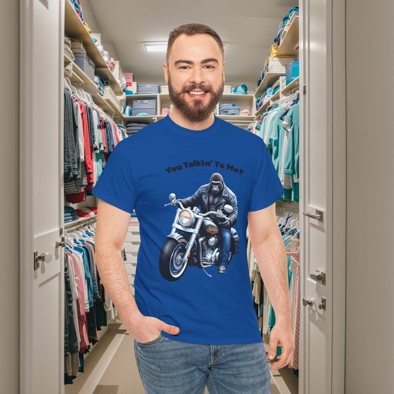 K&ouml;nnte beinhalten: K&ouml;nigsblaues T-Shirt mit einer Grafik eines Gorillas auf einem Motorrad und dem Text "You Talkin' To Me?". Das T-Shirt ist aus einem weichen Material. Ein Kleiderschrank ist im Hintergrund.