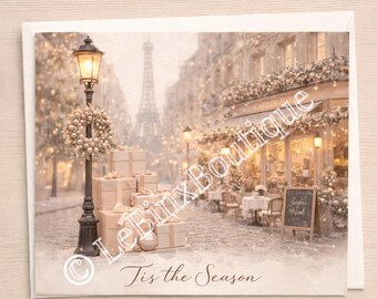 May include: A Christmas card featuring a Parisian street scene with a lamppost, gifts, and a cafe. The Eiffel Tower is visible in the background. The card reads "Tis the Season" in script.