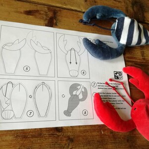 May include: A set of instructions for making a stuffed lobster toy. The instructions include diagrams and numbered steps. The image also shows a finished red lobster toy and a blue and white striped lobster toy.