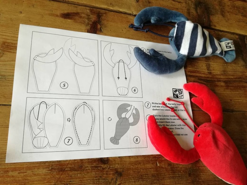 May include: A set of instructions for making a stuffed lobster toy. The instructions include diagrams and numbered steps. The image also shows a finished red lobster toy and a blue and white striped lobster toy.