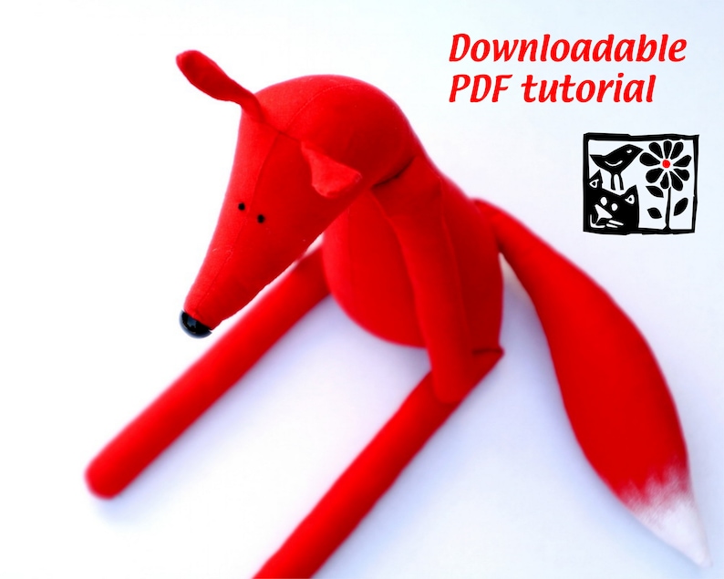 May include: Red fabric fox toy with a white tipped tail.  The fox is sitting on a white surface.  Downloadable PDF tutorial.