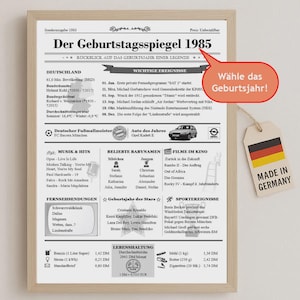 Könnte beinhalten: Gerahmter Druck "Der Geburtstagsspiegel 1985" mit deutschem Text, der Ereignisse, Musik und beliebte Namen aus dem Jahr 1985 hervorhebt. Enthält ein "Made in Germany"-Etikett. Der Druck befindet sich in einem hellen Holzrahmen.