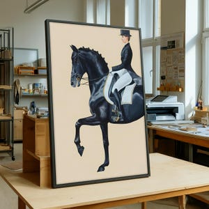 May include: Framed equestrian art print featuring a black horse and rider in formal attire. The artwork depicts a dressage scene with the horse in a raised pose. The rider is wearing a top hat and a black coat. The background is a light beige color.