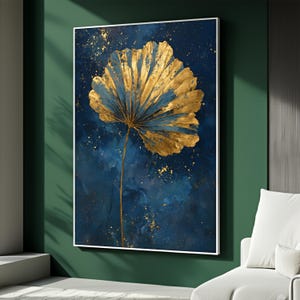 May include: Abstract art print featuring a large, stylized gold and blue leaf against a dark blue background. The artwork has gold flecks and is framed in white. The painting is displayed on a green wall.