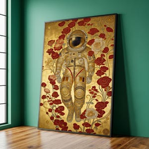 May include: A framed art print featuring a golden astronaut suit against a gold background with red and white roses. The astronaut is the focal point, with intricate details in the suit's design. The artwork is displayed on a wooden floor against a teal wall.