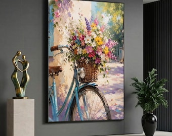 May include: A framed wall art print depicting a light blue bicycle with a brown wicker basket overflowing with a vibrant bouquet of pink, yellow, purple, and white flowers, set against a soft, sunlit outdoor path and a textured wall.