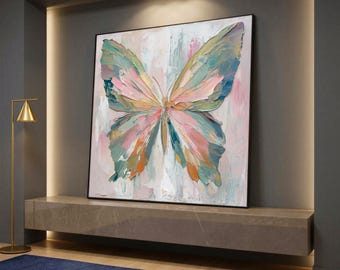 May include: Large framed butterfly painting with a textured, impasto style. The artwork features a butterfly with wings in shades of blue, green, pink, and orange against a light background. The painting is displayed on a stone shelf.