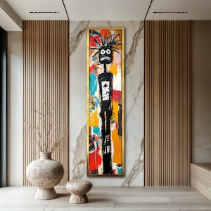 May include: Abstract artwork in a gold frame. The painting features a black figure with a spiky head and a wide-eyed expression against a colorful background of red, yellow, blue, and white brushstrokes. The artwork is displayed on a marble wall.