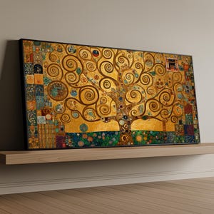 May include: A framed art print featuring a stylized golden tree with swirling branches and intricate details. The artwork has a mosaic-like background with various colors and patterns. The print is displayed on a wooden shelf.
