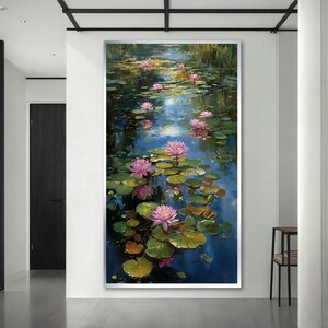 May include: A vertical wall art print featuring an oil painting of a pond filled with vibrant pink water lilies and green lily pads. The water reflects deep blue and golden light, creating a serene scene with multiple blooming flowers.