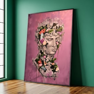 May include: A framed print featuring a classical bust adorned with colorful flowers against a pink backdrop. The bust is rendered in shades of gray, with floral accents in pink, orange, and purple. Black paint drips add a modern touch.