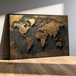 May include: A framed world map with a textured, three-dimensional appearance. The continents are rendered in a warm, metallic gold against a dark grey background. The map is displayed in a black frame and leans against a wall.