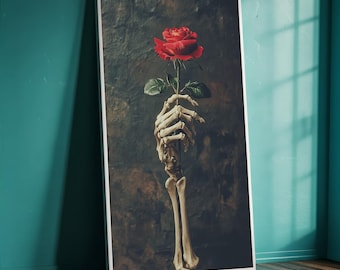 May include: A framed art print featuring a skeletal hand holding a red rose. The artwork has a dark, moody aesthetic with a textured background. The rose is in full bloom, contrasting with the bone-white hand.