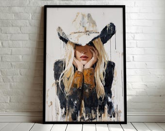 May include: A framed painting of a person wearing a cowboy hat, with long blonde hair and a black jacket. The artwork has a modern, abstract style with visible brushstrokes and a white background. The person's face is partially obscured.