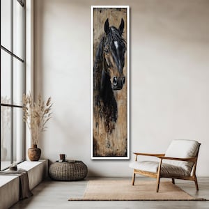 May include: A vertical framed painting of a horse's head. The horse has a dark brown coat with a white marking on its forehead. The background has a textured, neutral colour palette, with a white frame. The artwork is displayed in a modern living space.