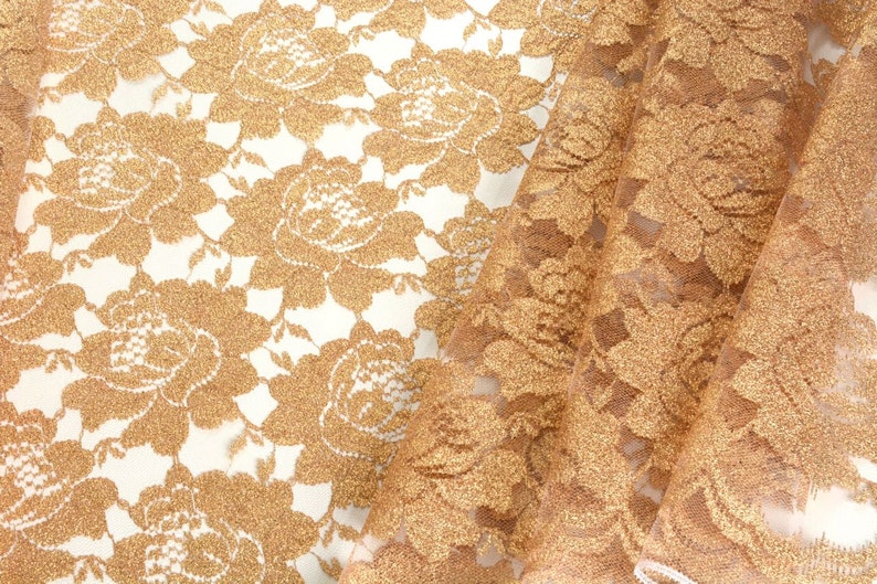 May include: Gold lace fabric with a floral pattern. The fabric is sheer and has a delicate texture.
