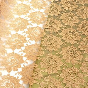 May include: Two pieces of gold lace fabric with a floral pattern. The fabric on the left is sheer and the fabric on the right is opaque.