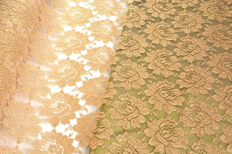 May include: Two pieces of gold lace fabric with a floral pattern. The fabric on the left is sheer and the fabric on the right is opaque.