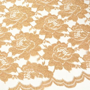 May include: Gold lace fabric with a floral pattern. The lace is delicate and intricate, with a subtle shimmer.