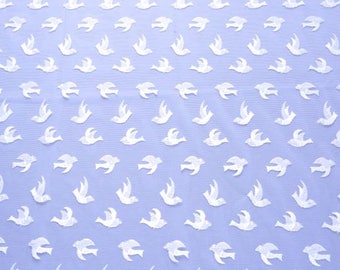 May include: Pale blue fabric featuring a repeating design of white bird shapes. The birds are depicted in different positions, some with outstretched wings, others in mid-flight. The material has a fine, open weave, ideal for clothing or interior design.