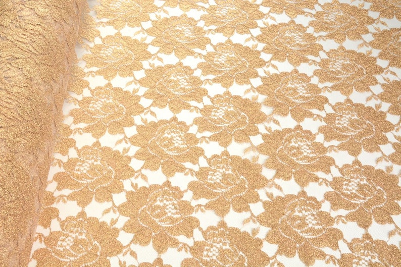 May include: Gold glitter lace fabric with a floral pattern. The lace is delicate and has a soft, shimmery finish.