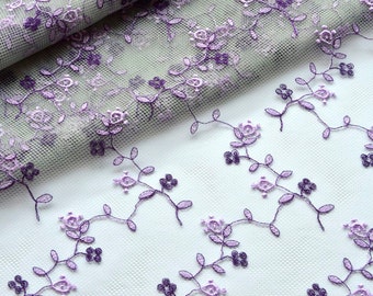 May include: Purple floral embroidery on a sheer white fabric. The embroidery features delicate flowers and leaves.