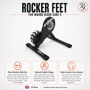Op de afbeelding: Zwarte rocker feet voor Wahoo Kickr Core 2 fietstrainer. Het apparaat heeft een zwart frame, een zilveren cassette en een zwart-wit chevronpatroon onderdeel. Tekst bevat ROCKER FEET FOR WAHOO KICKR CORE 2 en KICKR CORE.