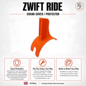 Può includere: Un copri-pedivella arancione brillante Zwift Ride caratterizzato da un design curvo con una fessura verticale. Il testo ZWIFT RIDE CRANK COVER / PROTECTOR è visualizzato sopra l'oggetto, con dettagli sulla protezione dal sudore e l'adattamento.