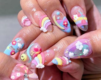 May include: A set of long, almond-shaped nails with colorful, whimsical designs. Each nail features a unique combination of rainbows, flowers, clouds, and smiley faces in pastel shades. Some nails have 3D embellishments, creating a playful and artistic manicure.