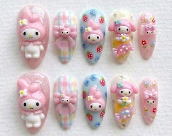 May include: A collection of ten artificial nails, each with a unique design. The nails showcase pink My Melody characters, bows, strawberries, and flowers. The nails are painted in pastel shades and have a glossy finish.